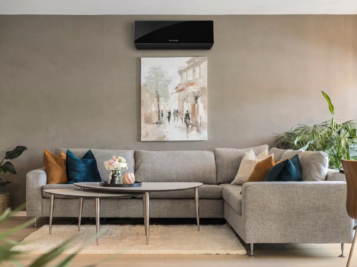 Klimatyzator ścienny Kaisai PRO HEAT+ 7 kW czarny na ścianie nowoczesnego salonu nad sofą